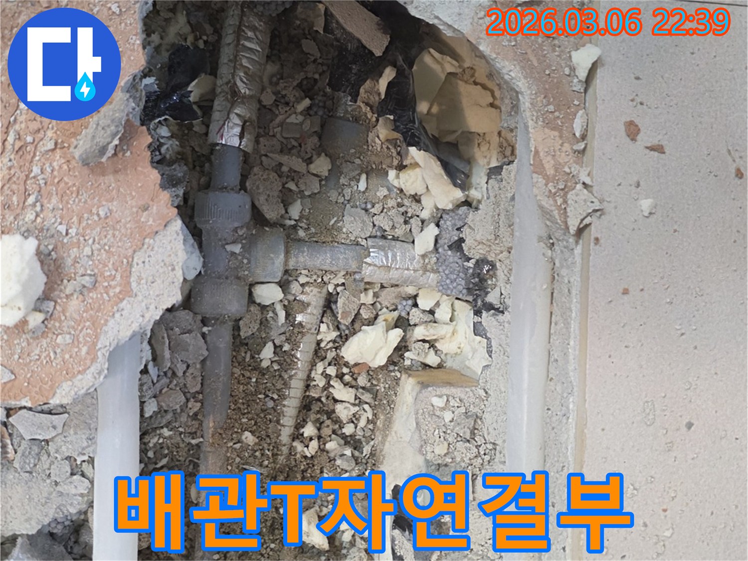 양주-백석읍-부흥로-주택에서-누수-전문가가-바닥을-개방하여-복잡하게-얽힌-배관의-T자-연결부와-주변-자재들을-정밀하게-분석하는-모습입니다.