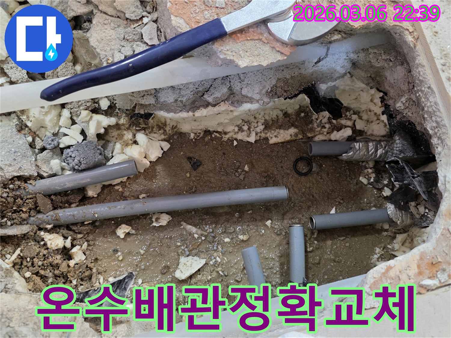 이 이미지는 온수 배관에서 발생한 누수를 해결하기 위해-손상된 온수 배관을 새로운 것으로 교체하는 작업 현장입니다