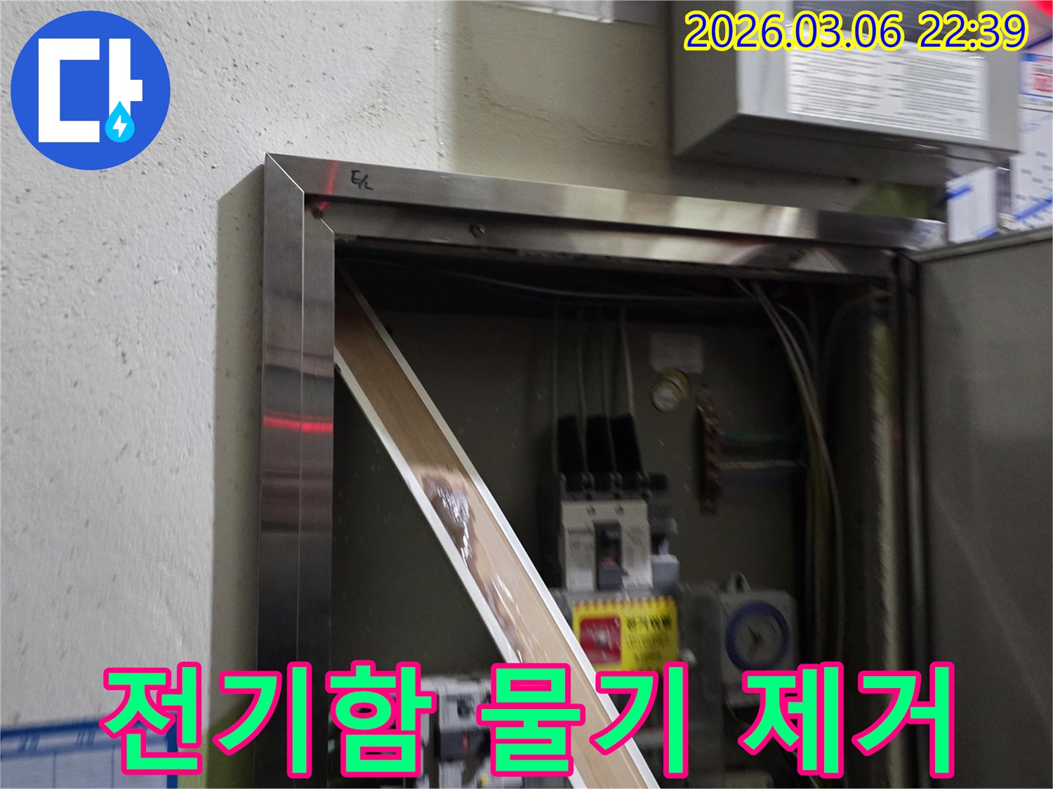 이 이미지는 전기함 내부로 유입된 물기를-제거하고 있는 현장을 보여주며-안전한 전기 사용을 위한-복구 작업의 중요성을 강조합니다.