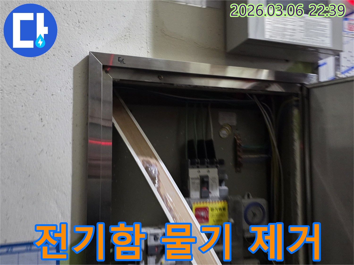 이 이미지는 전기함 내부로 유입된 물기를-제거하고 있는 현장을 보여주며-안전한 전기 사용을 위한-복구 작업의 중요성을 강조합니다.