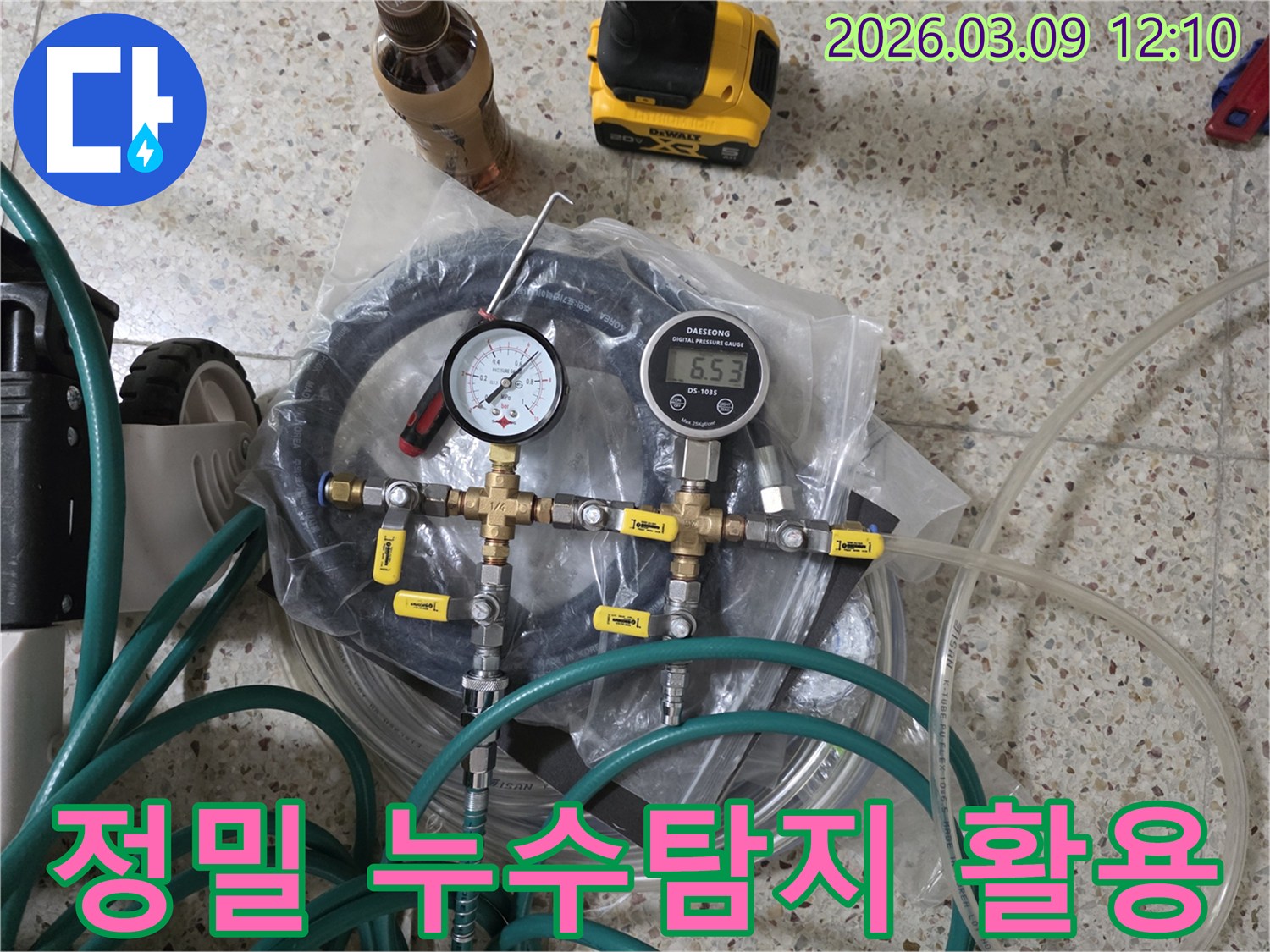 누수 공사를 위한 정밀한 누수탐지 장비들이-압력계-호스-밸브 등과 함께 바닥에 가지런히 놓여 있습니다.
