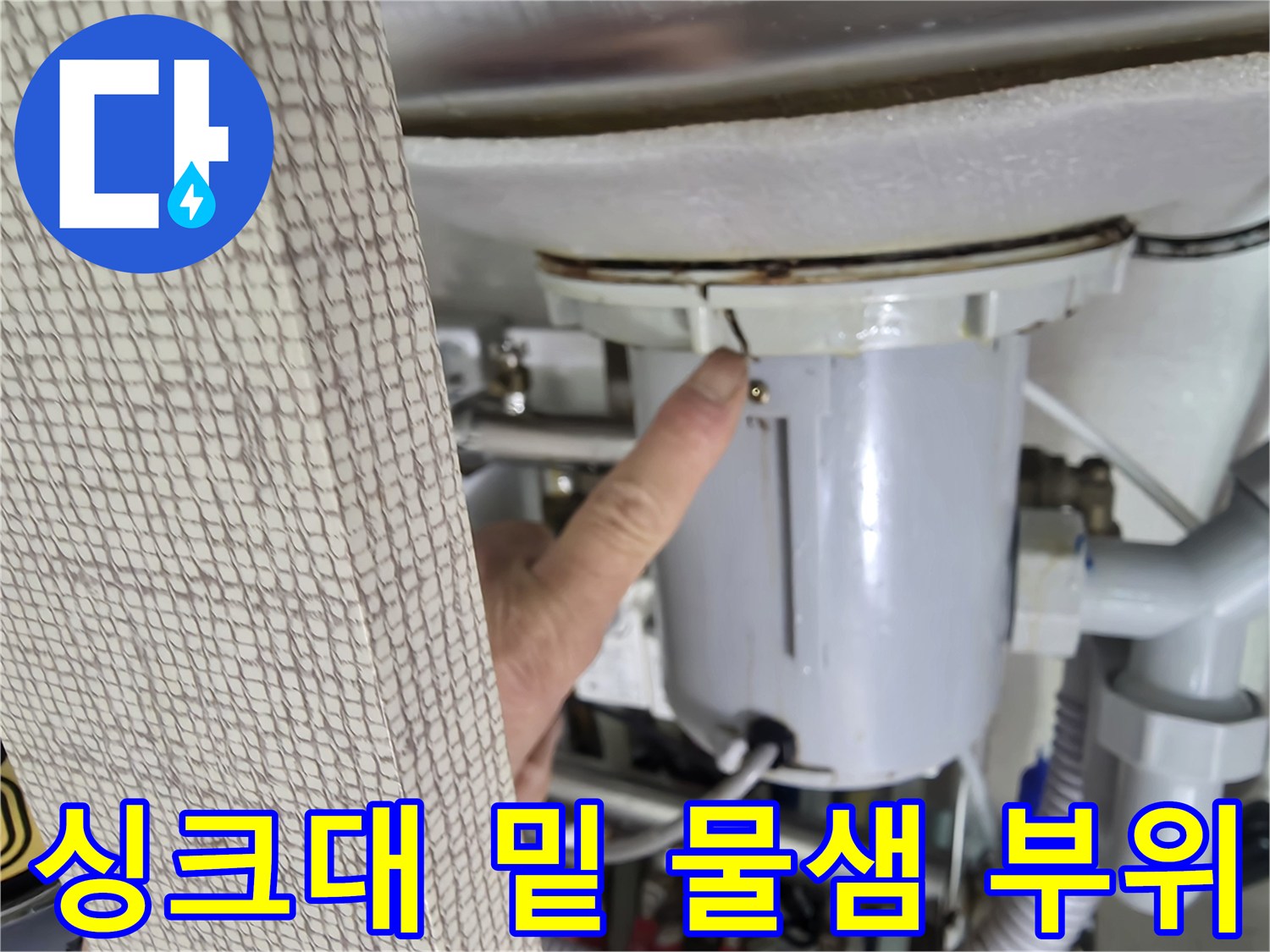 누수 지점-싱크대 하단 배관 틈새를 확인하는 작업자 손가락