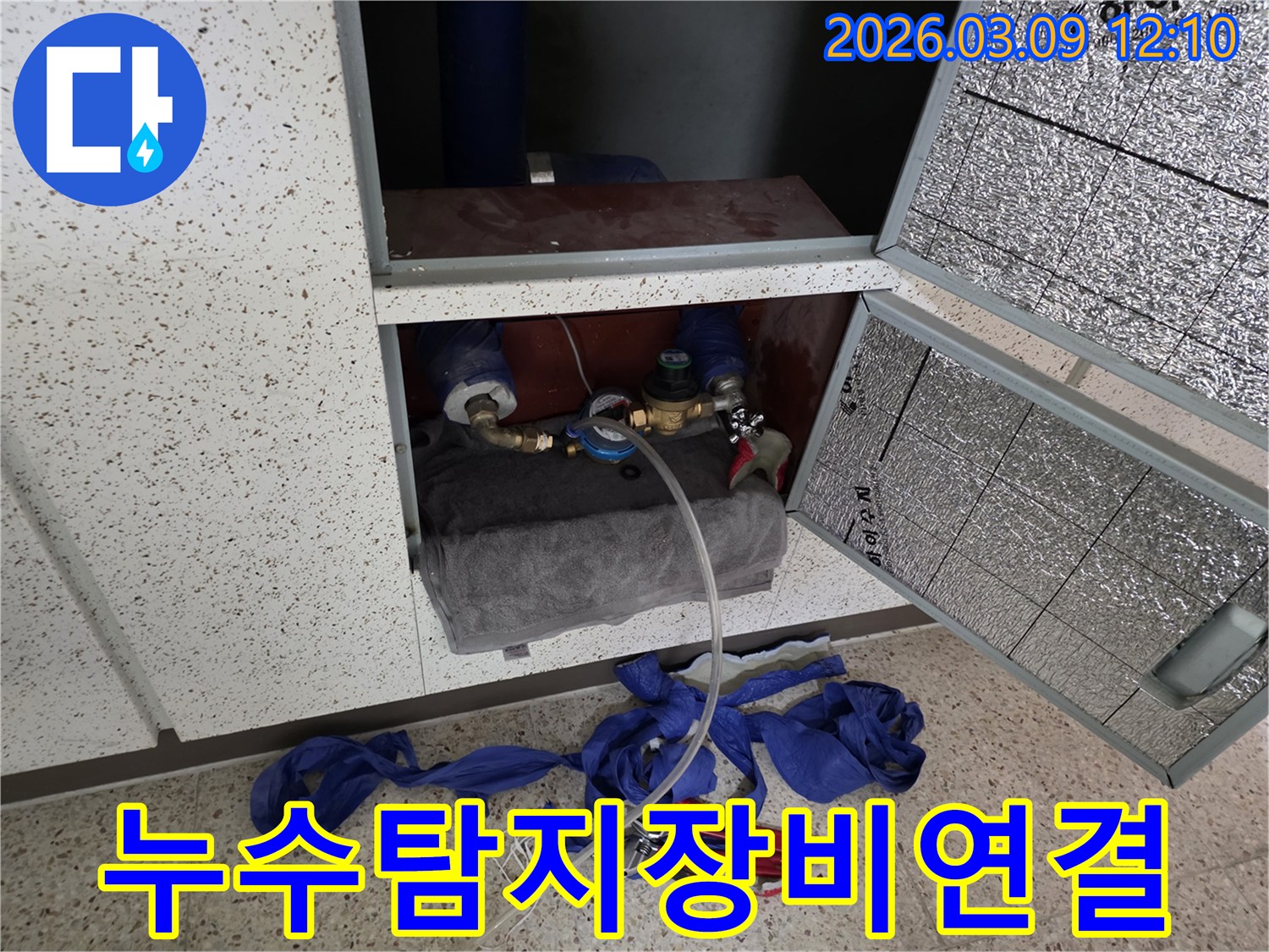 온수관-누수-탐지를-위해-배관에-전문-장비를-연결하여-압력-테스트를-진행하는-장면입니다