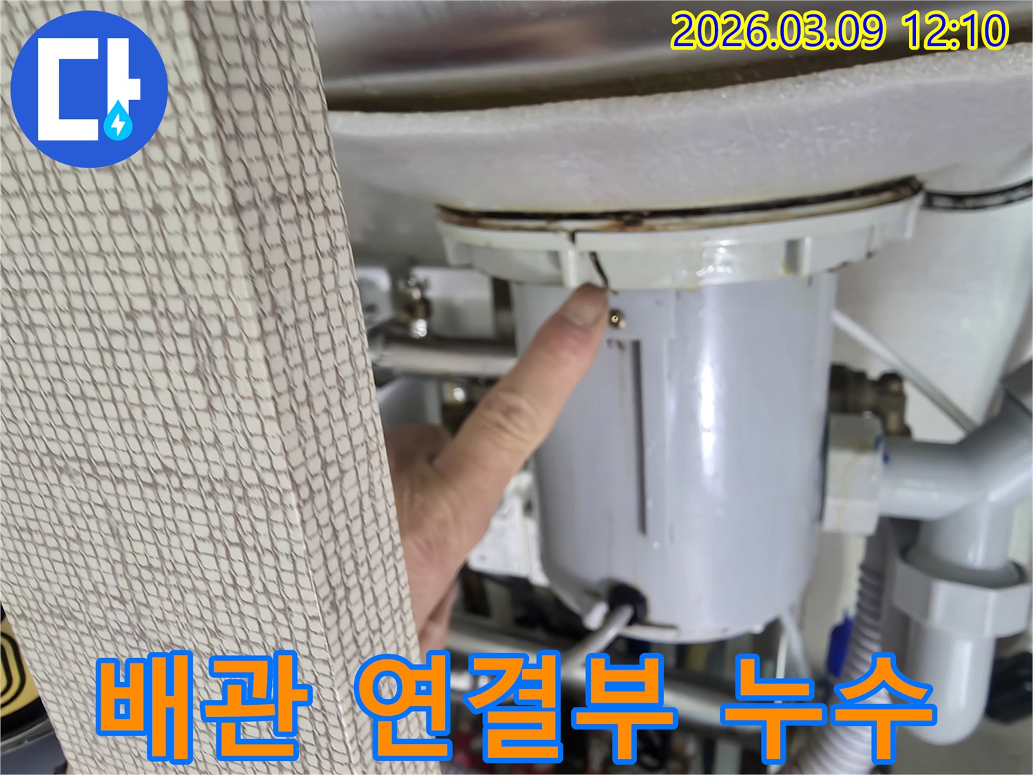 전문가가-배관 연결부의-미세한 틈새를-누수 원인으로-지목하며-고객에게-상황을-설명하는-모습입니다.