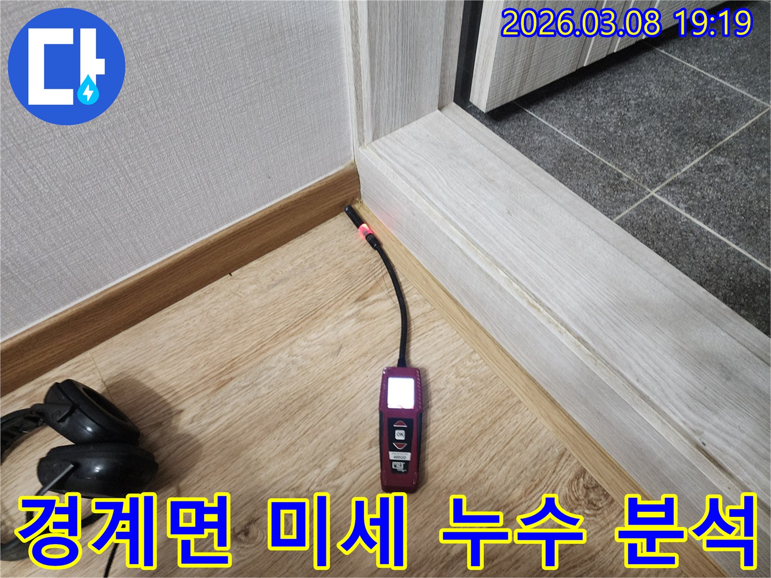 나무-마루와-벽면-사이의-틈새에서-누수탐지기가-작동하여-습기-반응을-보이는-사진
