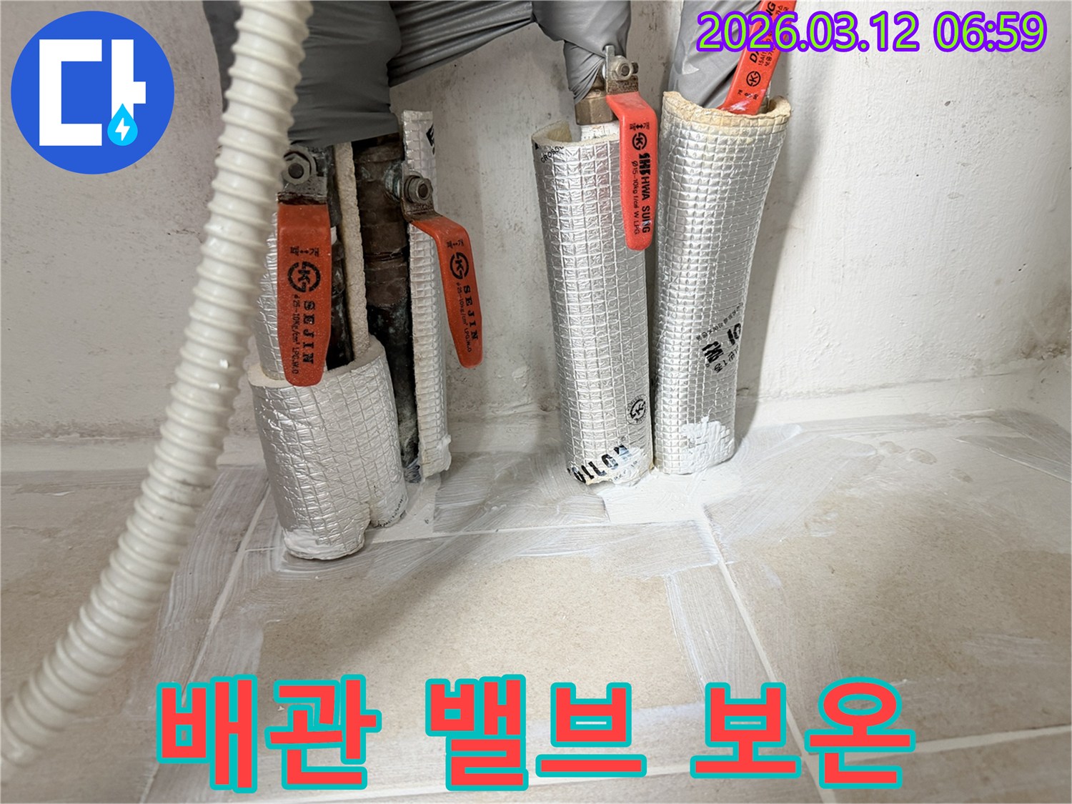 누수-공사-중-배관-밸브에-보온재를-꼼꼼히-감싸는-작업-현장