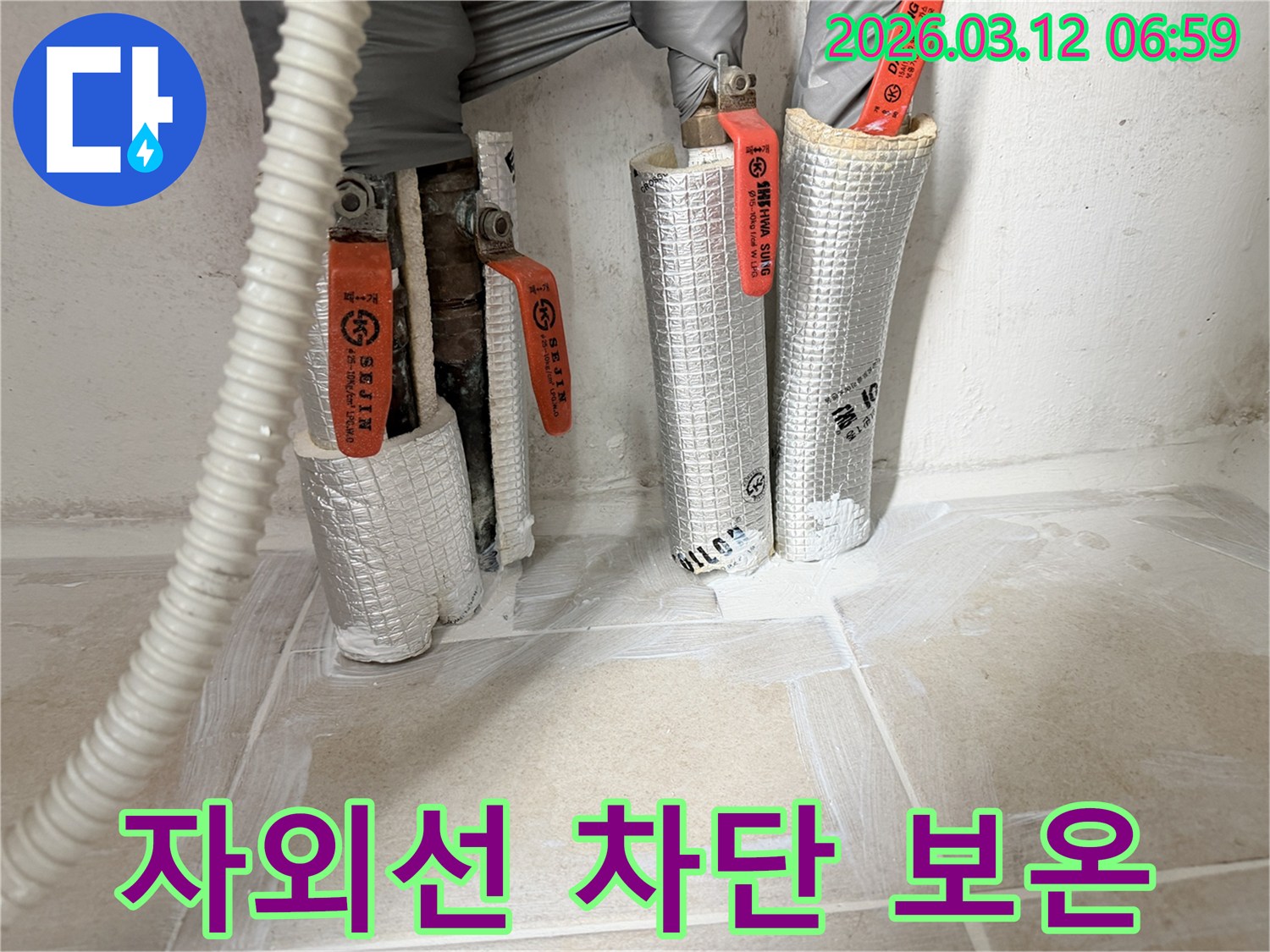 누수-공사-현장에서-자외선에-노출되는-배관에-특수-보온재를-시공하는-모습