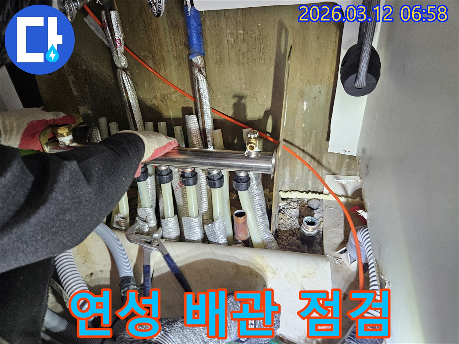 마포구-주택의-보일러-분배기에-연결된-연성-배관의-누수-여부를-전문가가-점검하는-모습입니다