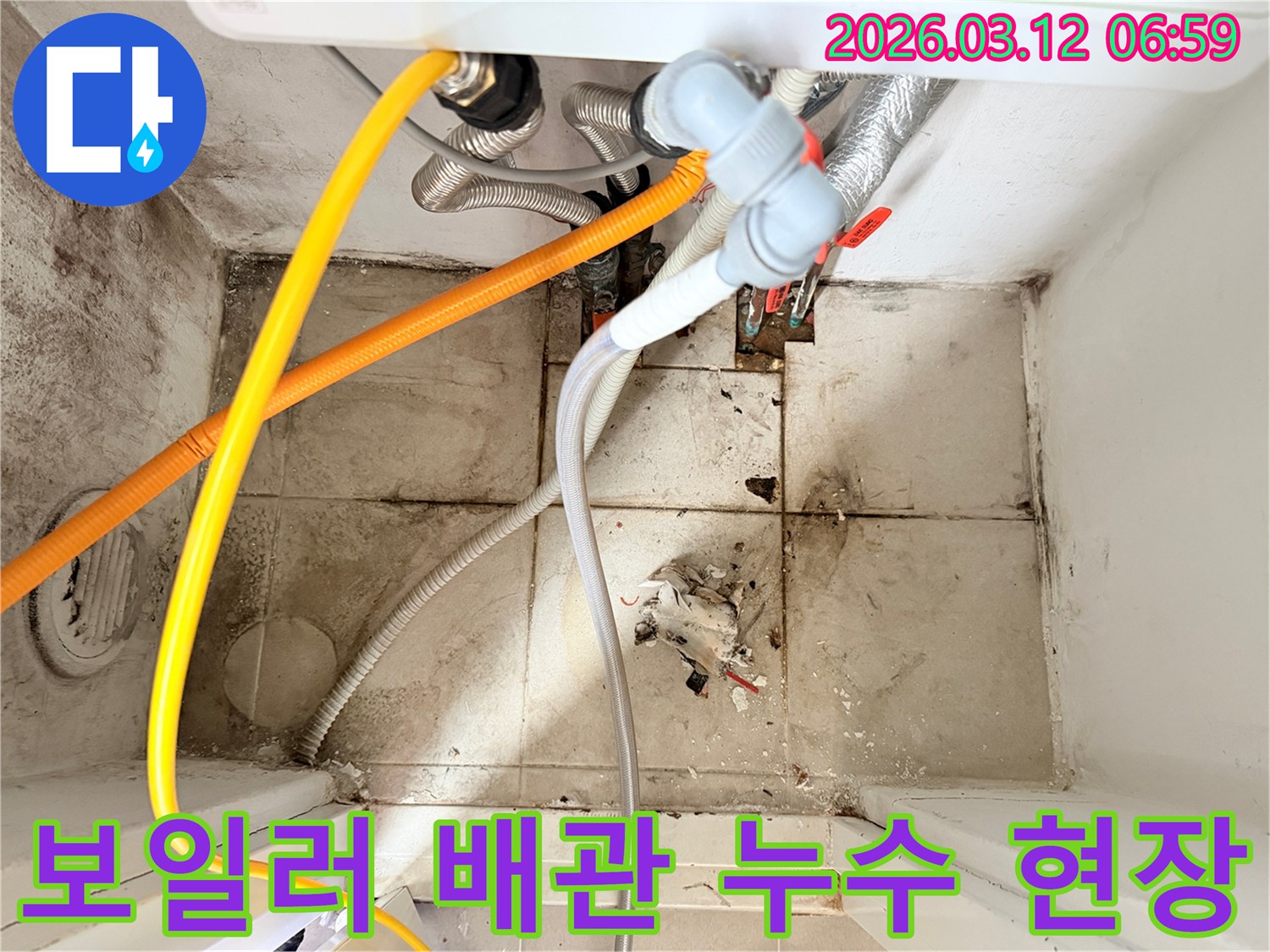 보일러와 연결된-다양한 배관들이 보이고-바닥에는 누수로 인한-오염과 곰팡이가 있는-현장 사진입니다.