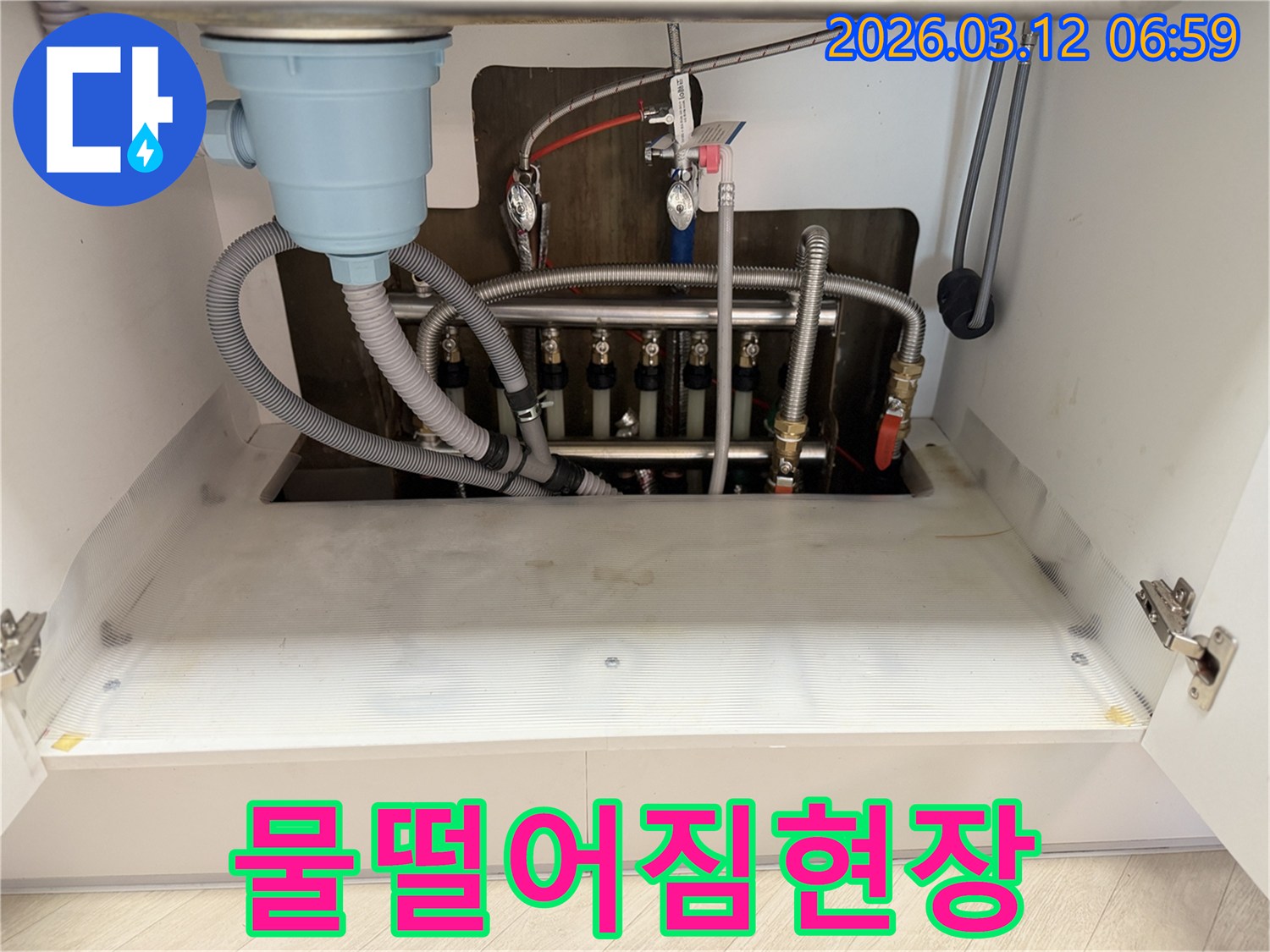 싱크대-밑에서-물이-떨어지는-현상을-해결하기-위해-마포구-누수-전문가가-배관을-점검하는-모습입니다.