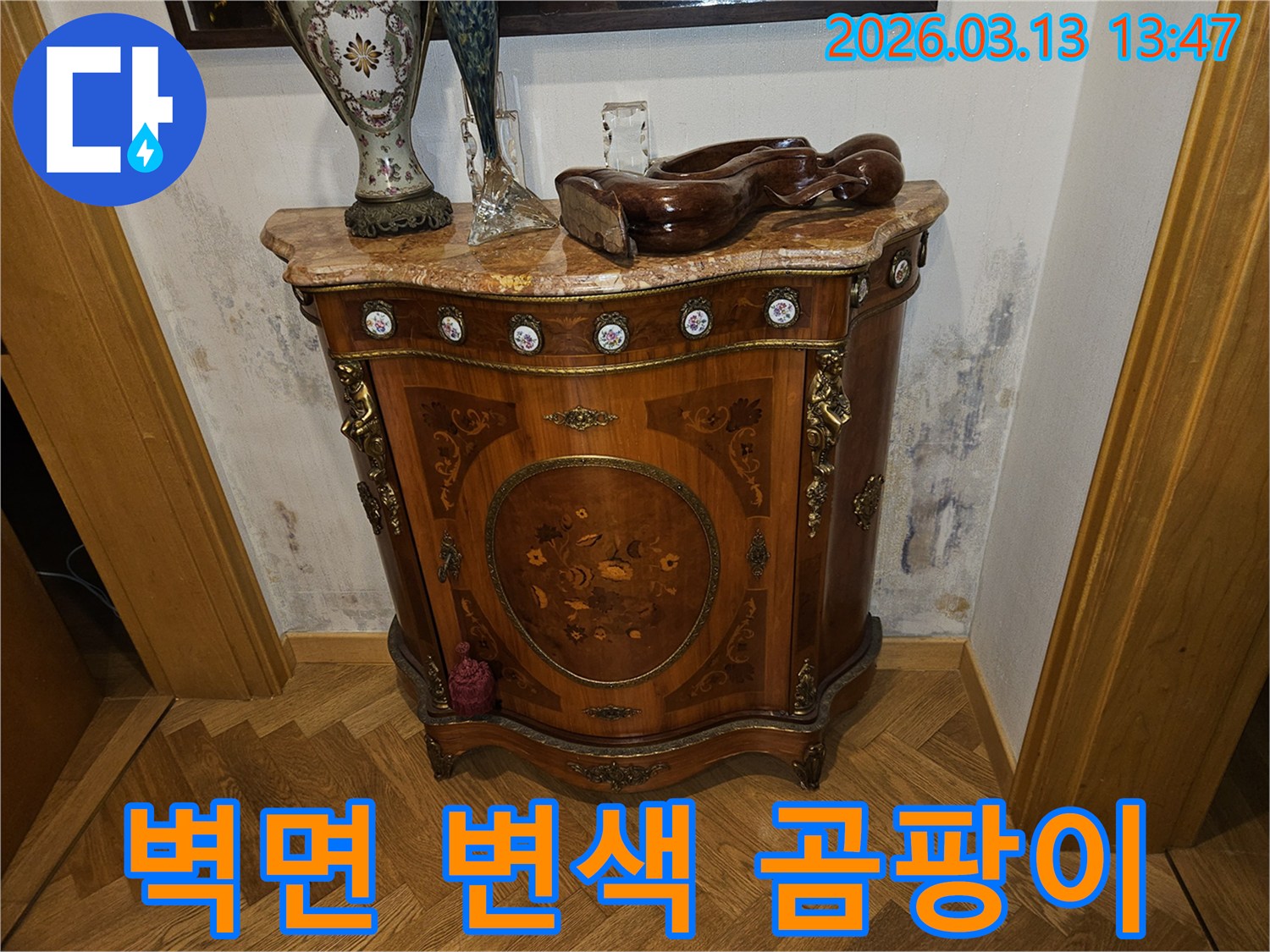 고풍스러운 가구 뒤-벽에 나타난-누수로 인한-벽면 변색과-심한 곰팡이 흔적