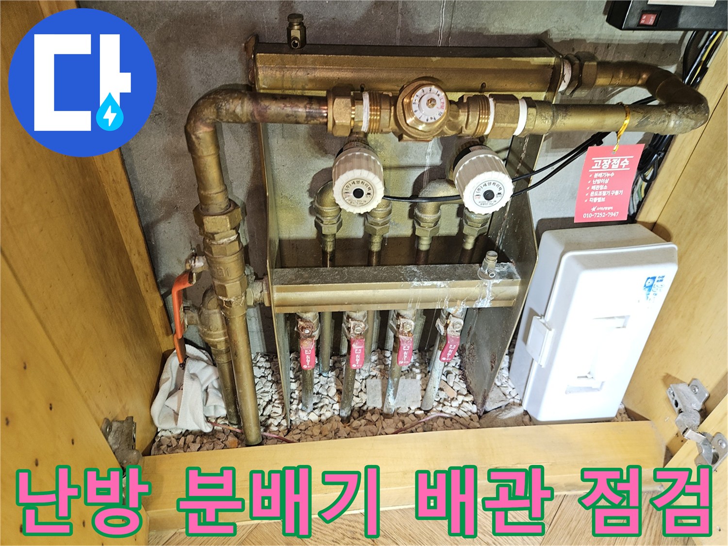 금속제 난방 분배기와 디지털 계량기가 설치된 배관실 내부