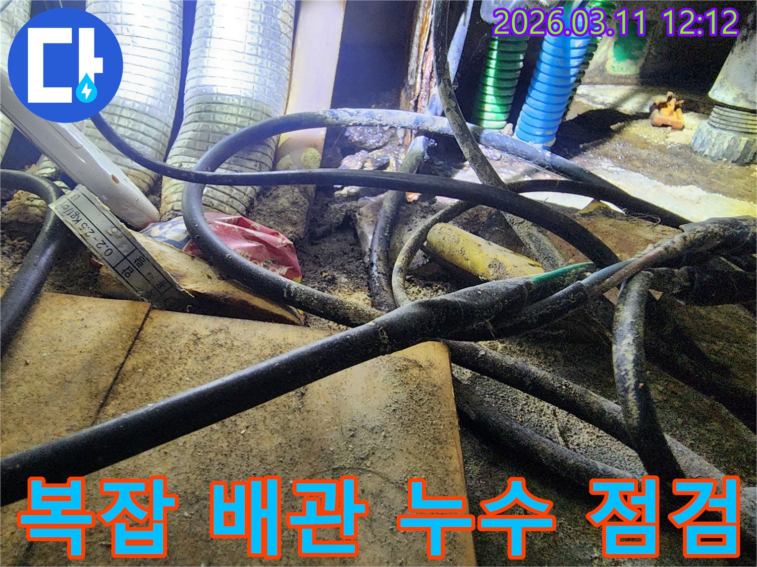 누수-현장에서-복잡하게-얽힌-배관과-전선-사이의-오염된-모습을-담은-사진입니다.