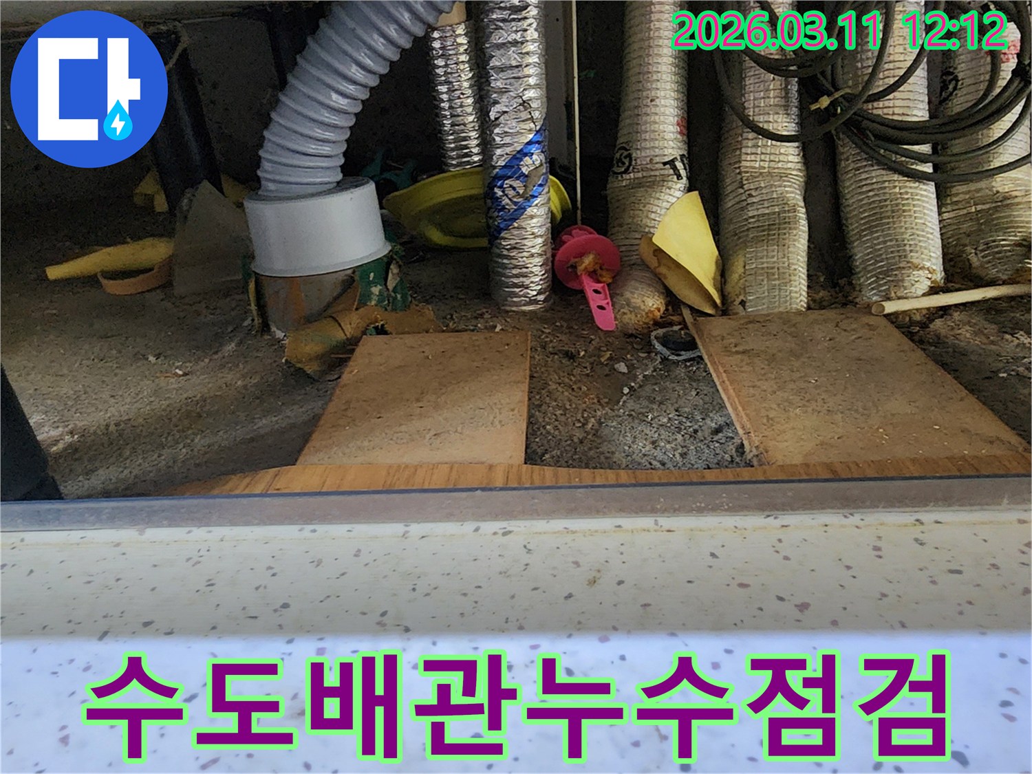 수도-배관-주변에서-누수-원인을-찾기-위해-전문가가-꼼꼼히-점검하는-모습을-담은-사진입니다