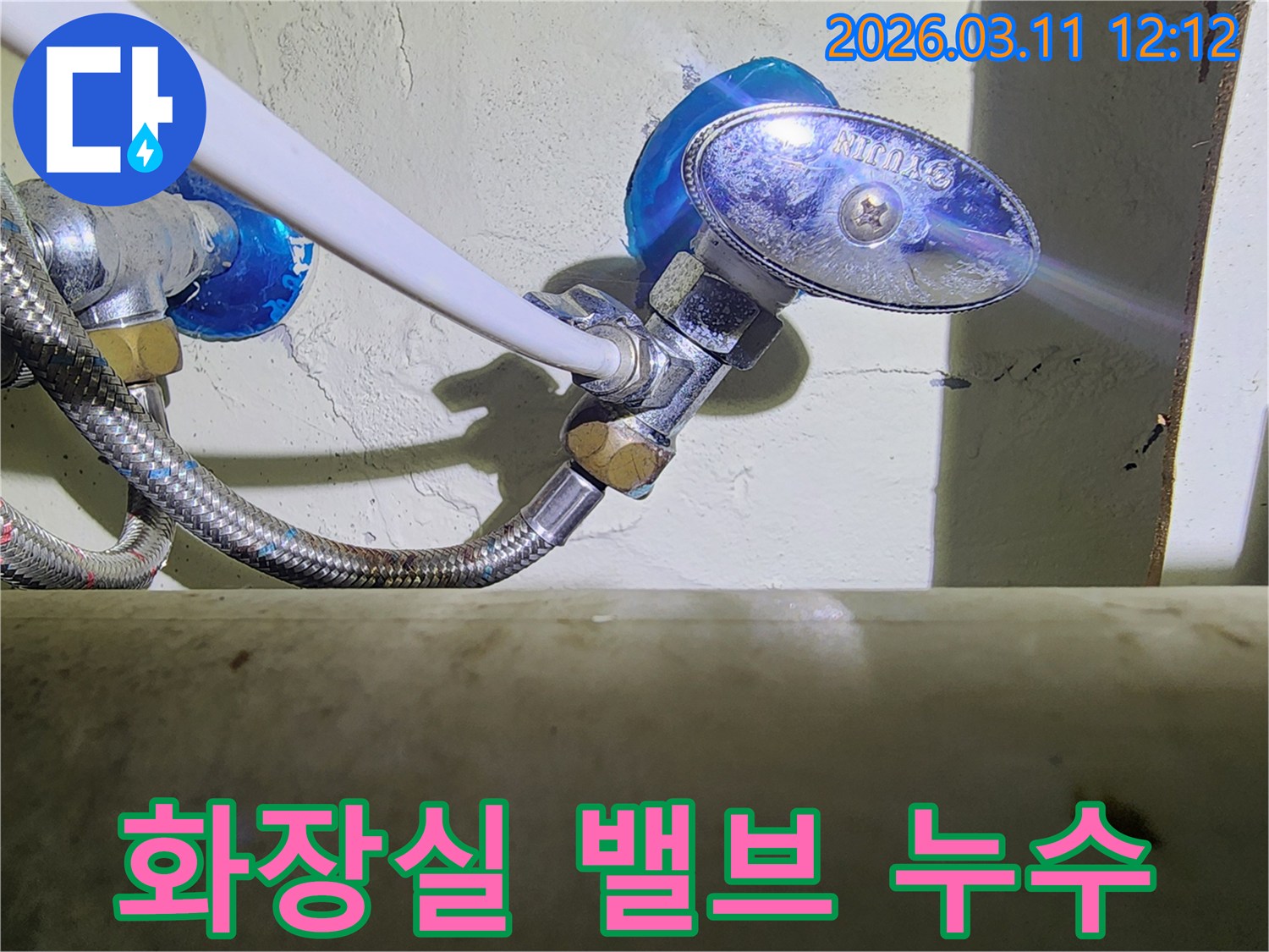 화장실-벽면에-설치된-수도-밸브와-고압호스-연결부에서-발생한-물샘-현상을-확인하는-모습입니다.