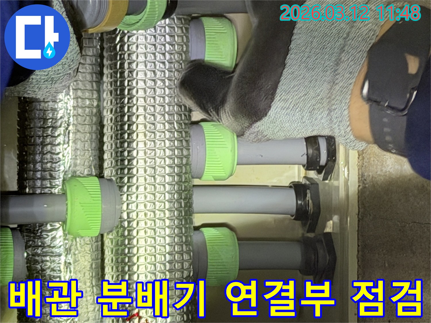 김포-지역의-전문-엔지니어가-배관-분배기의-연결-지점을-세심하게-확인하며-누수-여부를-판단하고-있습니다.