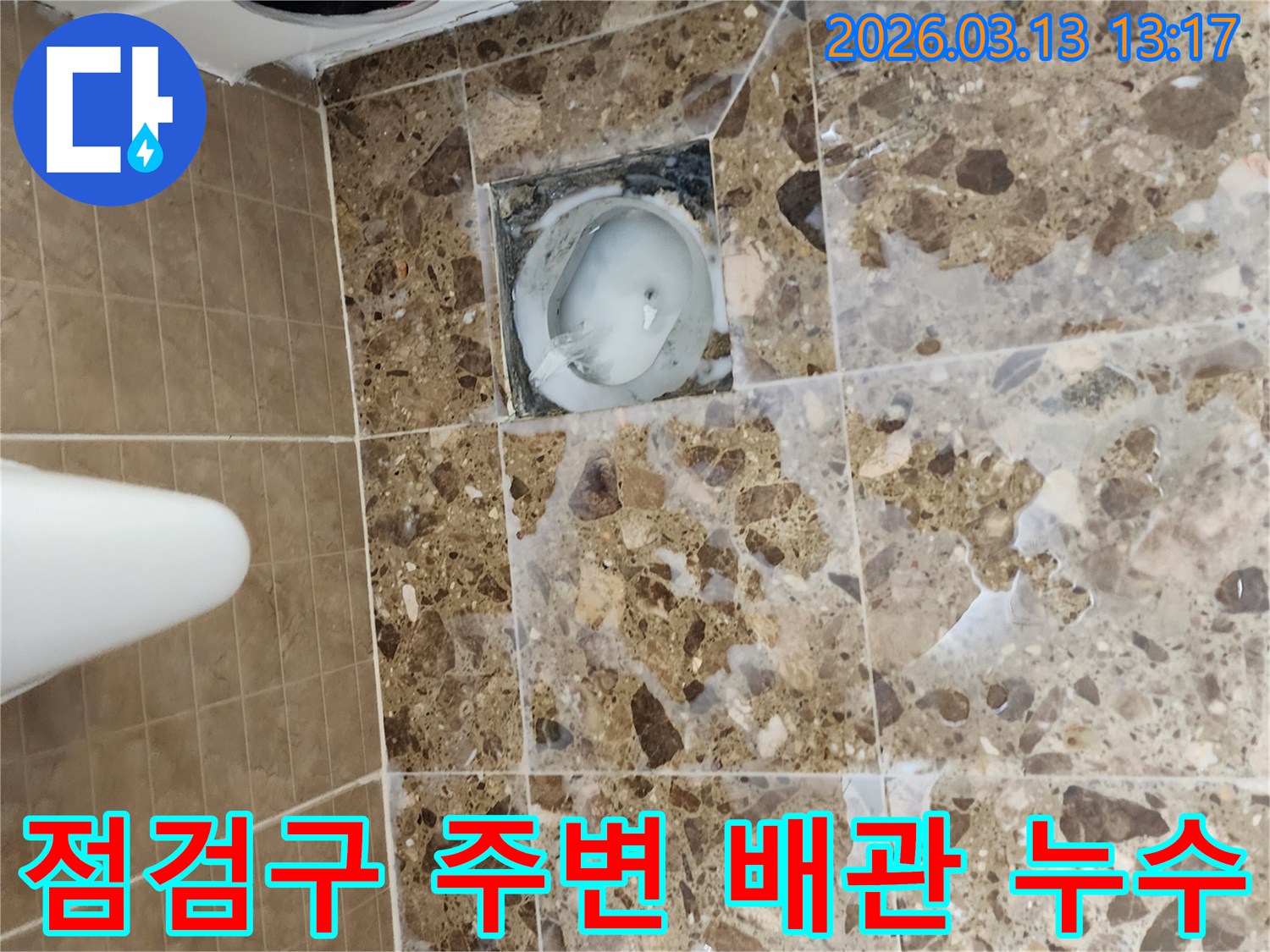 화장실 벽면의 점검구 주변에서-발생한 누수 문제를-점검하고-배관 상태를 확인하는 모습입니다.