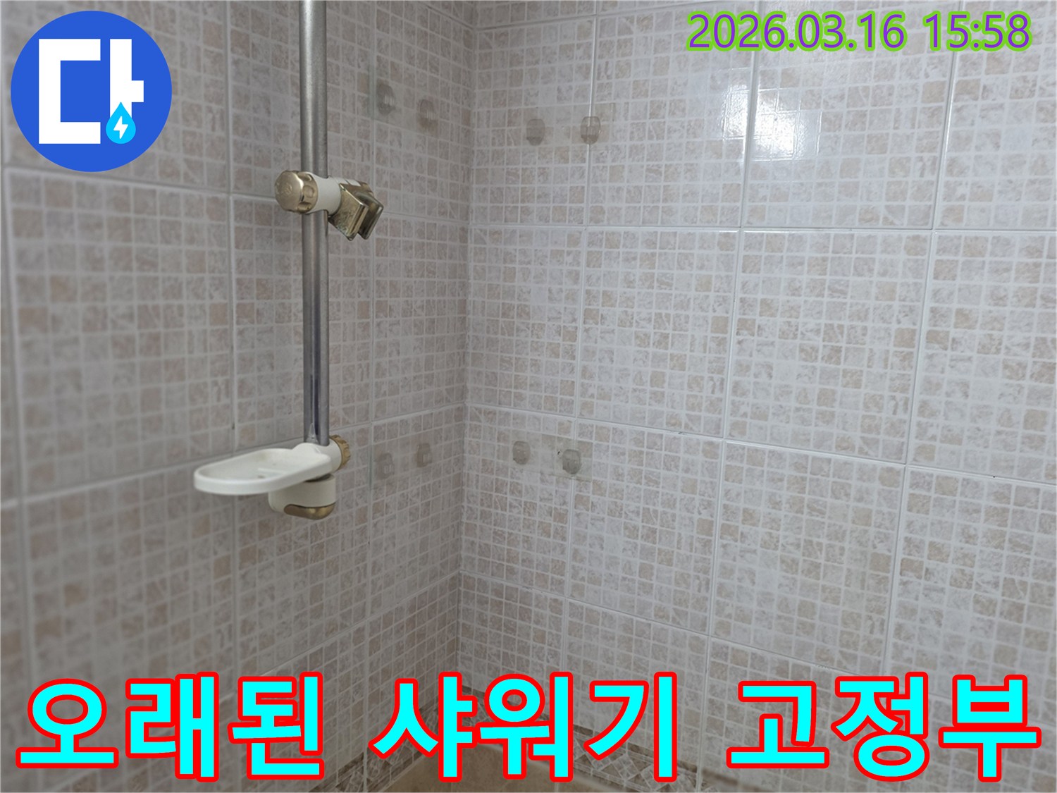 오산 운암로 주택 욕실의-오래된 샤워기 고정부 주변 타일 벽면을-누수 위험을 확인하기 위해-점검하는 모습