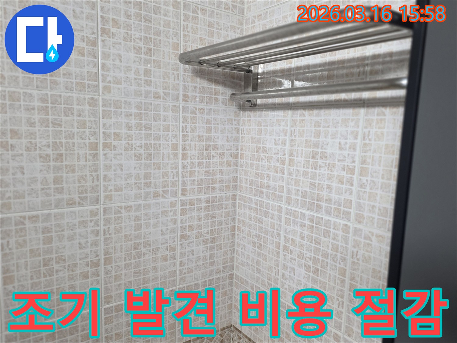 욕실 타일 벽면을-보며 누수 엔지니어가-누수 조기 발견의-비용 절감 효과를-고객에게 설명하는 모습입니다.