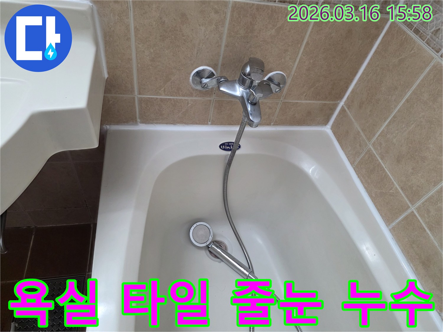 이 사진은-욕실-타일-사이의-줄눈-상태를-점검하며-누수-가능성을-확인하는-모습으로-욕조와-수도꼭지가-함께-보입니다