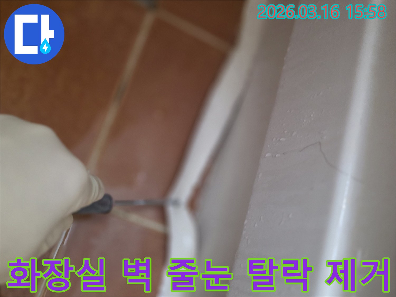 주거 공간 화장실 벽면 줄눈의-오래되고 탈락된 부분을-전문가가 제거하는 작업 현장