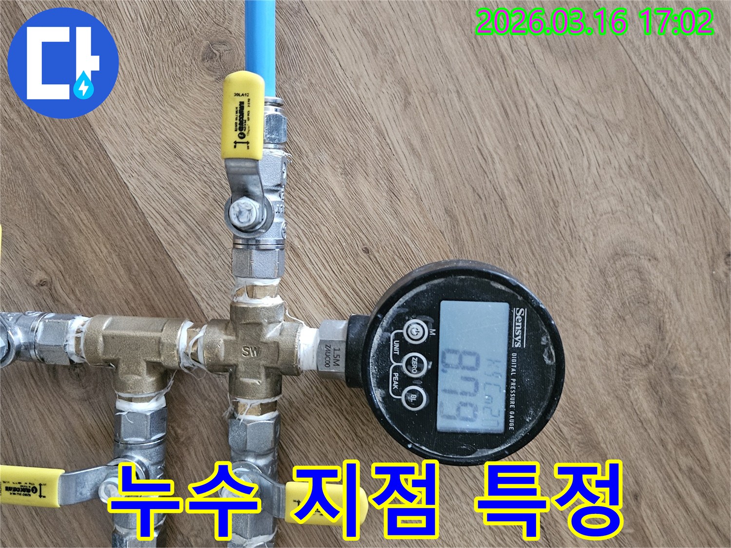누수 탐지 전문가가-배관에 압력 게이지를 연결하여-누수 지점을 정확히 찾아내는 모습입니다.