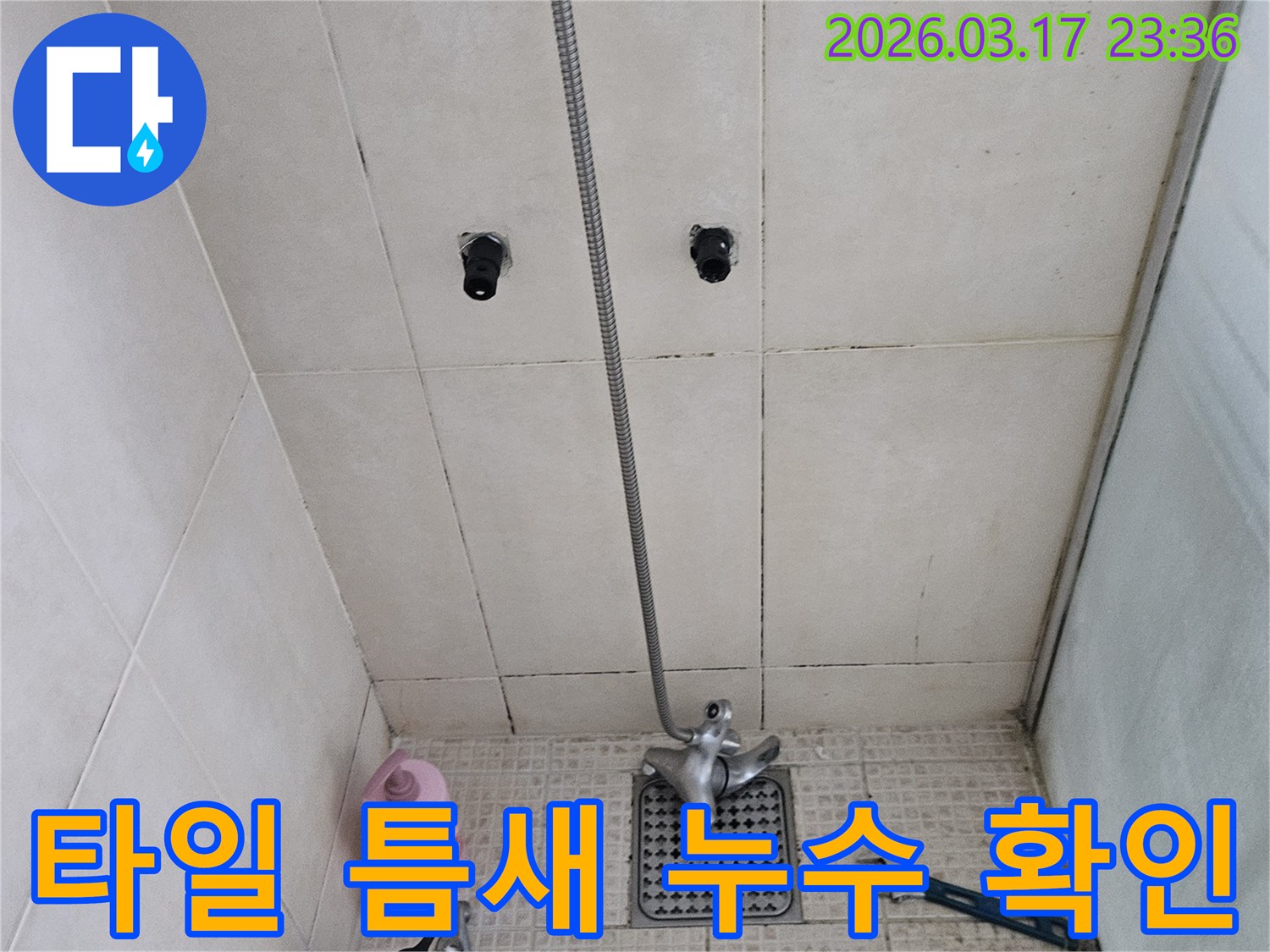 고객님 댁의-화장실 타일-틈새에서-발생한-누수를-해결하기 위해-저희 팀이-배관 상태를-면밀히-살펴보고 있는-현장 사진입니다.