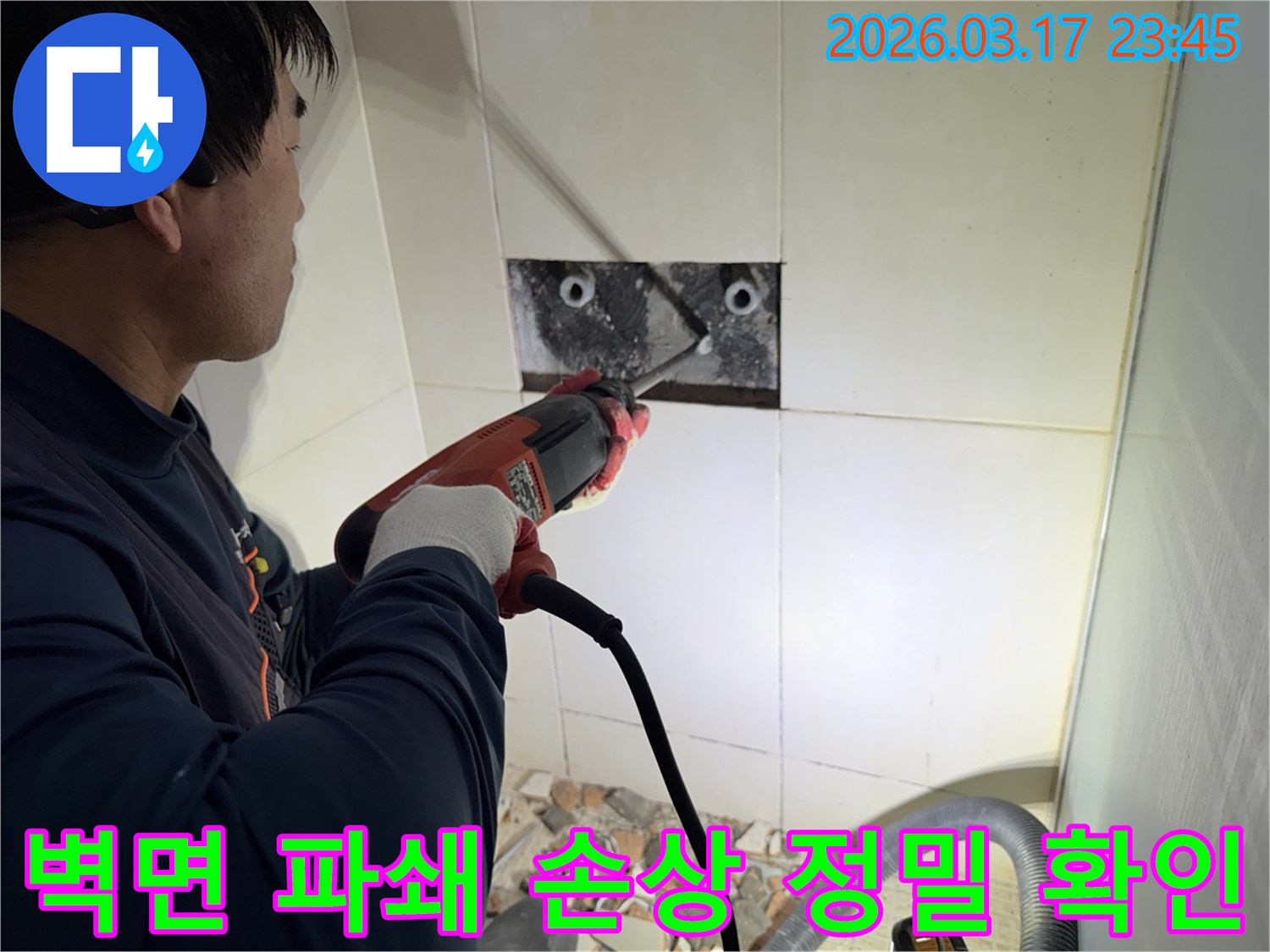 누수 전문가가 벽면 타일을 깨끗하게 파쇄하며-누수 원인인 배관의 손상 부위를 정밀하게 확인하는 작업을 진행 중입니다.