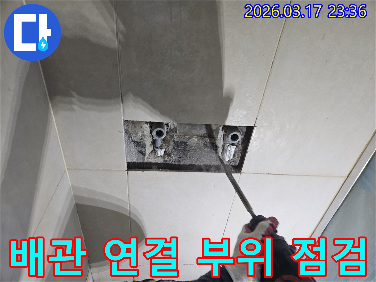 누수 지점을-찾기 위해-타일이 제거된-벽면에서-배관 연결 부위를-점검하는-모습입니다