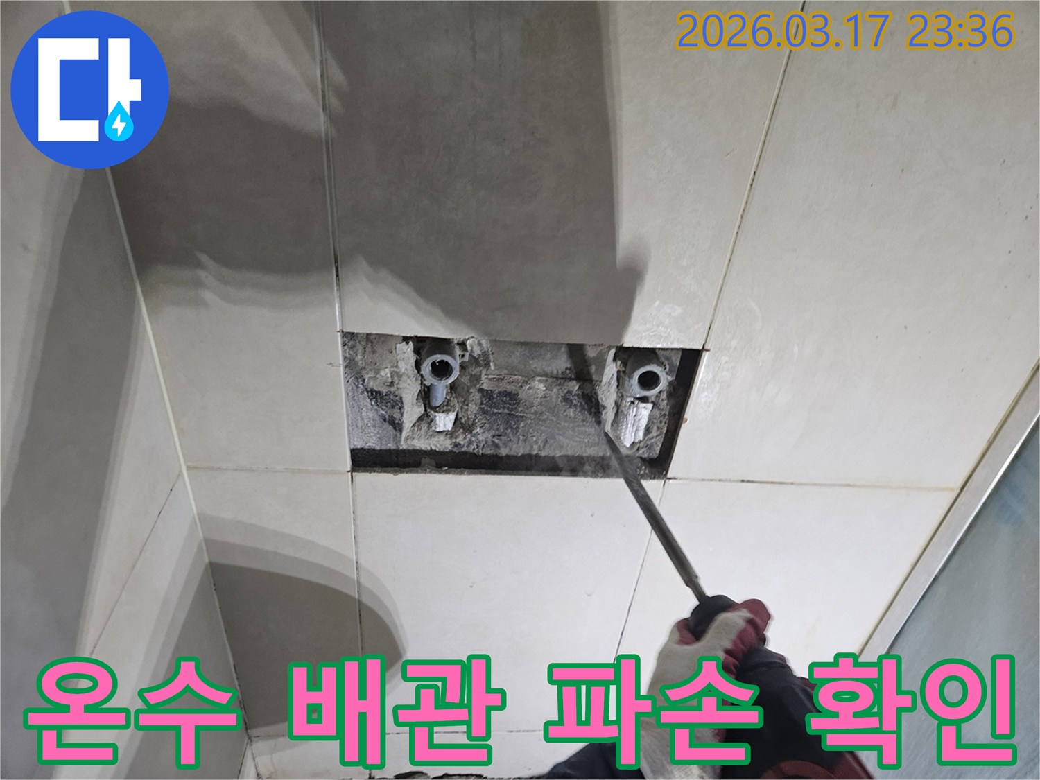 누수 지점을-찾기 위해-타일이 제거된-벽면에서-온수 배관의-파손 여부를-점검하는-모습입니다