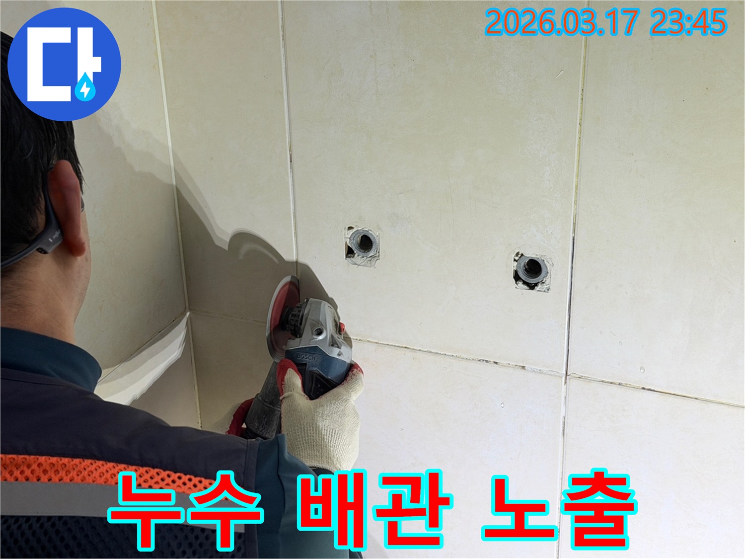 누수된 배관을-노출시키기 위해-전문가가-타일 벽면을-그라인더로-조심스럽게-커팅하고-있습니다
