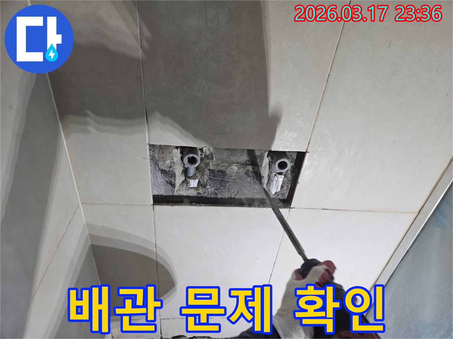 누수탐지-전문가가-욕실 벽면 타일을-조심스럽게 파쇄하여-배관 문제를-확인하는 모습
