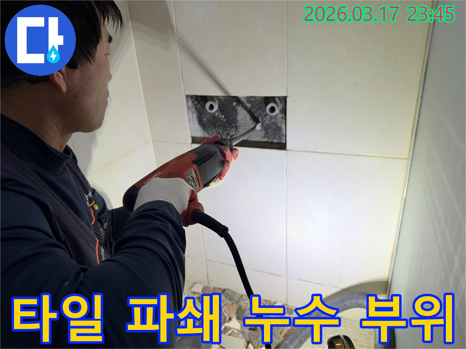 숙련된 기술자가 누수 지점을 찾아내기 위해-벽면 타일을 깨고 내부 배관을 드러내는 작업을 진행하고 있습니다.