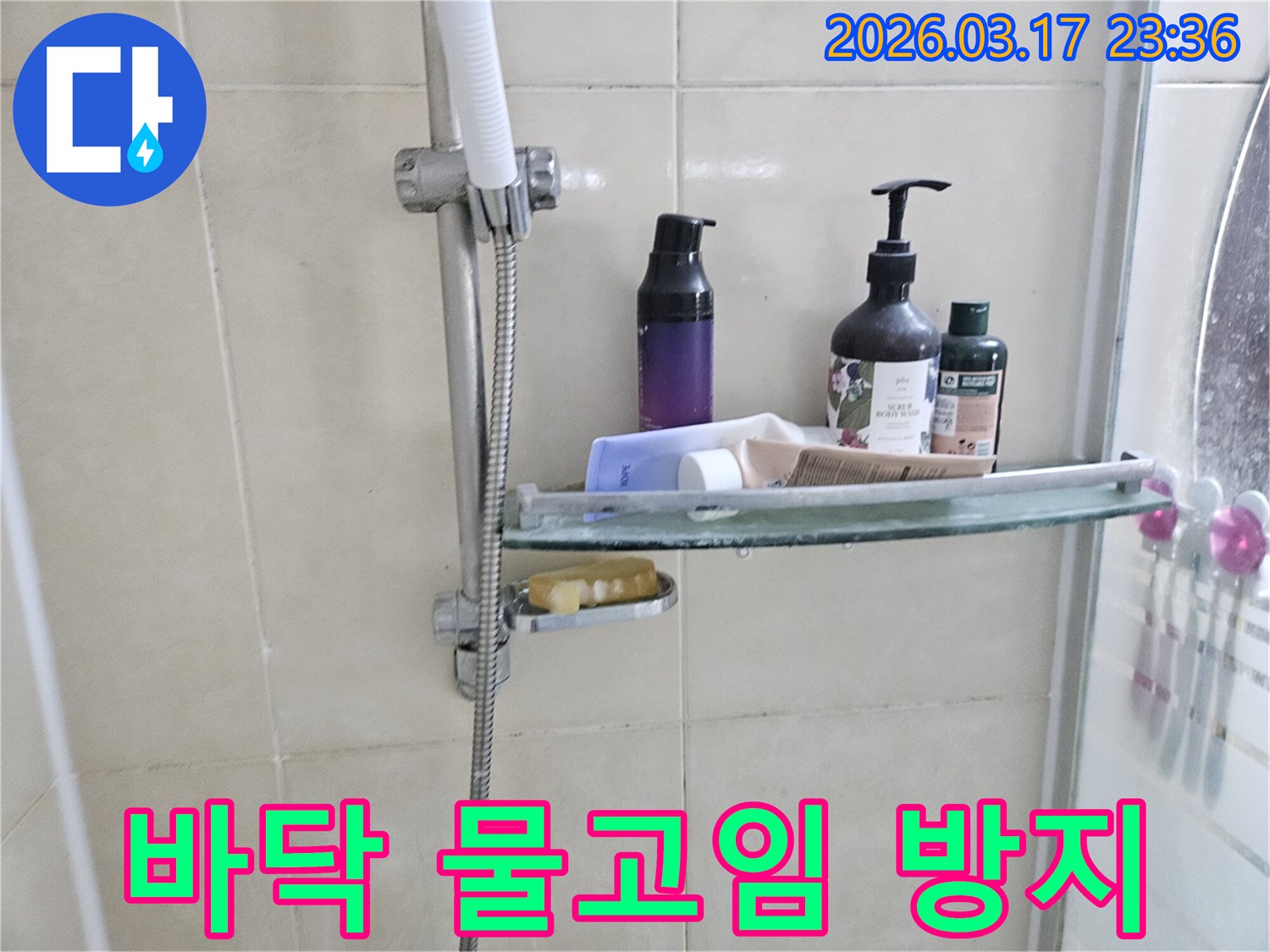 욕실 샤워기 옆-유리 선반에 맺힌 물방울은-바닥 물고임의 간접적인 증거를 보여주는 이미지입니다