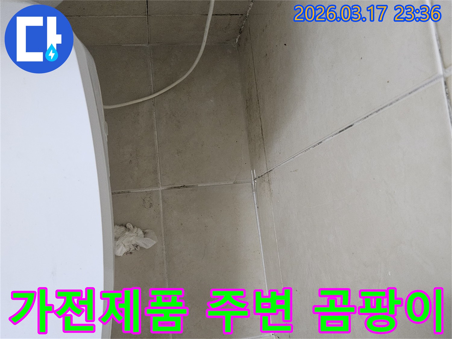 이-이미지는-하얀-가전제품-위에-위치한-천장과-벽면-타일에-발생한-심각한-곰팡이와-오염을-보여주며-이는-누수로-인한-가전제품-피해-가능성을-시사합니다