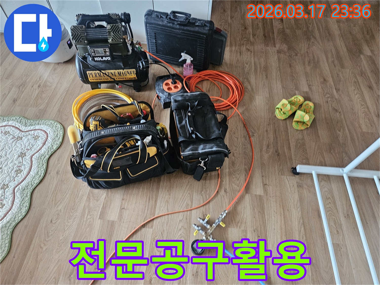 주거 공간 바닥에 놓인 누수 탐지 장비들-정밀한 압력 테스트를 위한 도구와 노란색 공구함이 보입니다.