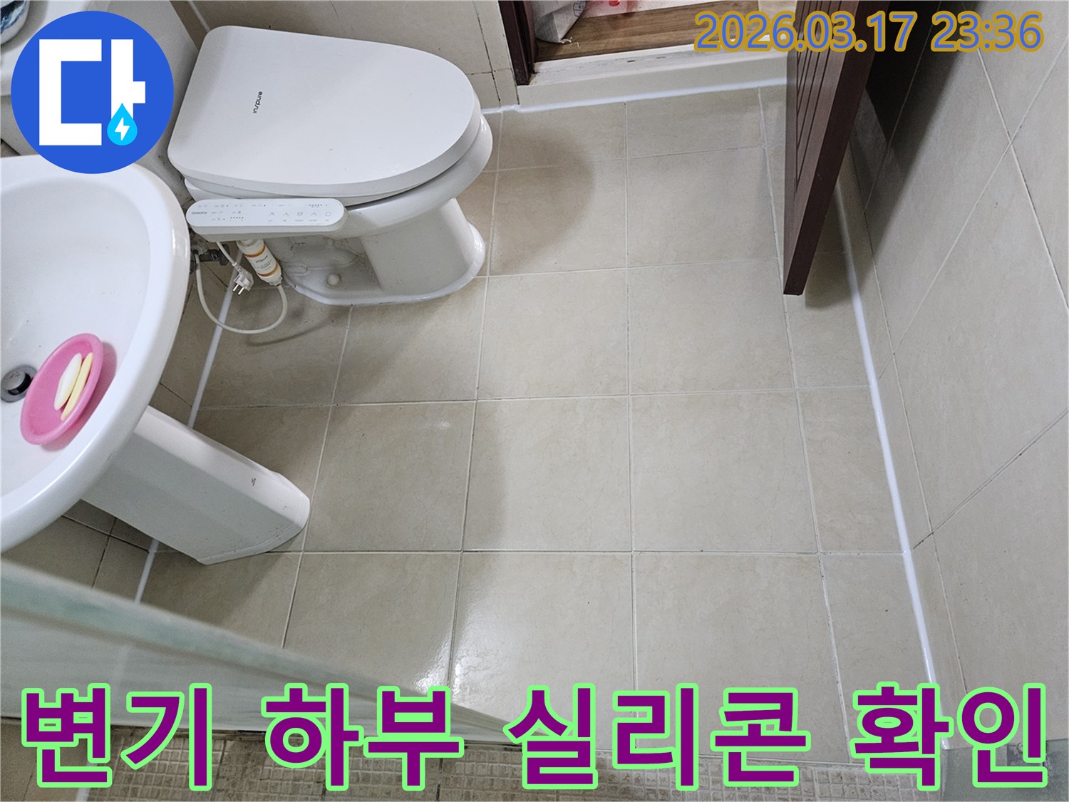 주택 욕실 변기 하부의 실리콘 마감 상태를-누수 발생 가능성 여부를 확인하기 위해-면밀히 점검하는 모습입니다