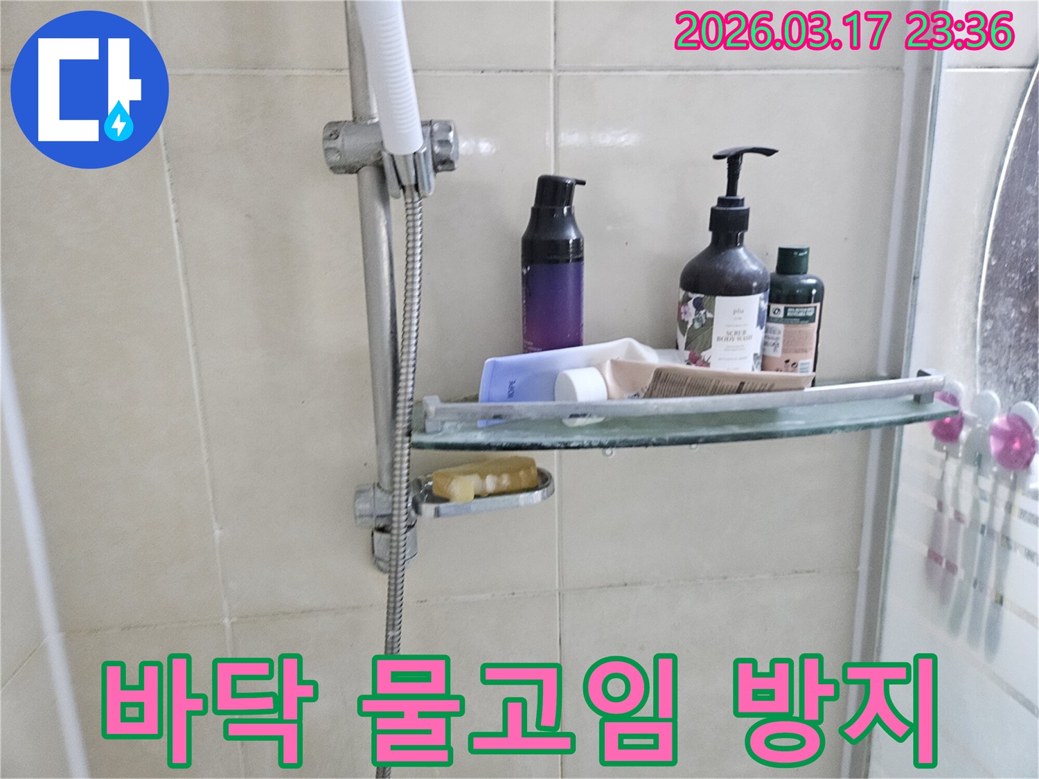 화장실 샤워기 옆-유리 선반에 맺힌 물방울은-바닥 물고임의 간접적인 증거를 보여주는 이미지입니다