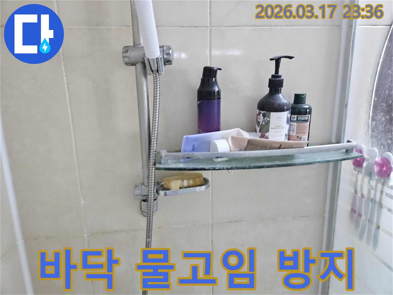 화장실 샤워기 옆-유리 선반에 맺힌 물방울은-바닥 물고임의 간접적인 증거를 보여주는 이미지입니다