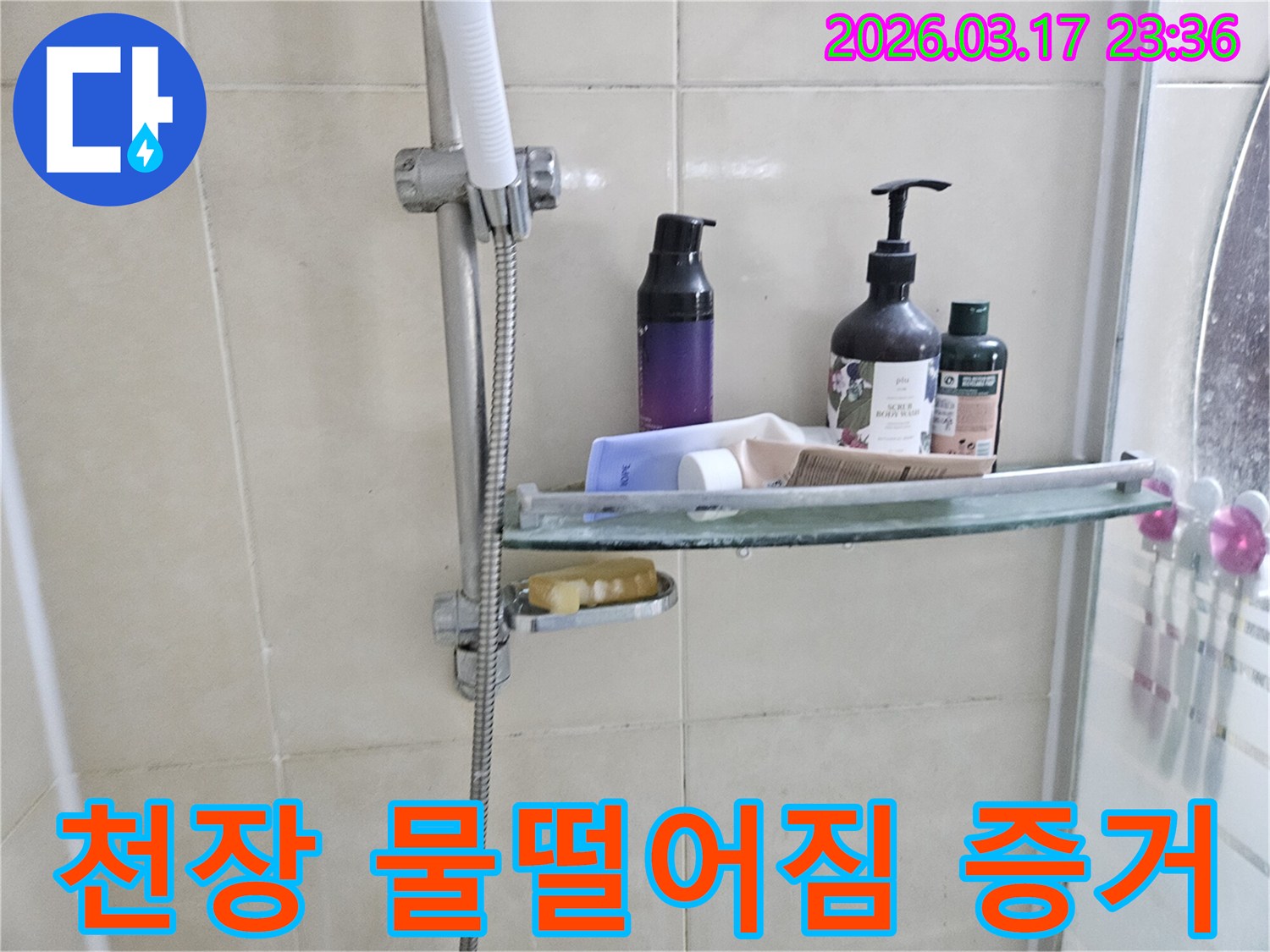 화장실 샤워기 옆-유리 선반에 맺힌 물방울은-천장 누수의 간접적인 증거를 보여주는 이미지입니다