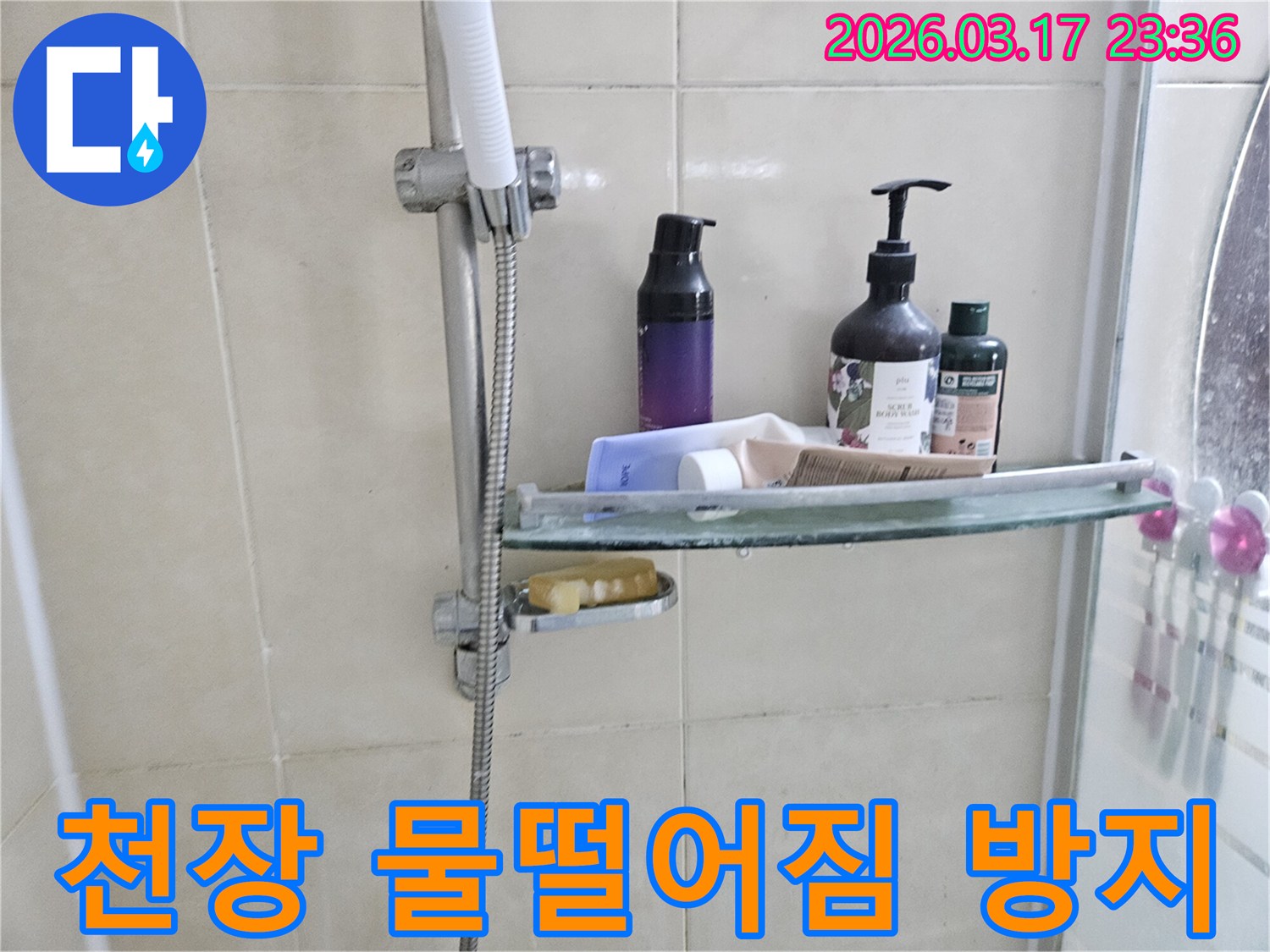 화장실 샤워기 옆-유리 선반에 맺힌 물방울은-천장 물떨어짐의 간접적인 증거를 보여주는 이미지입니다