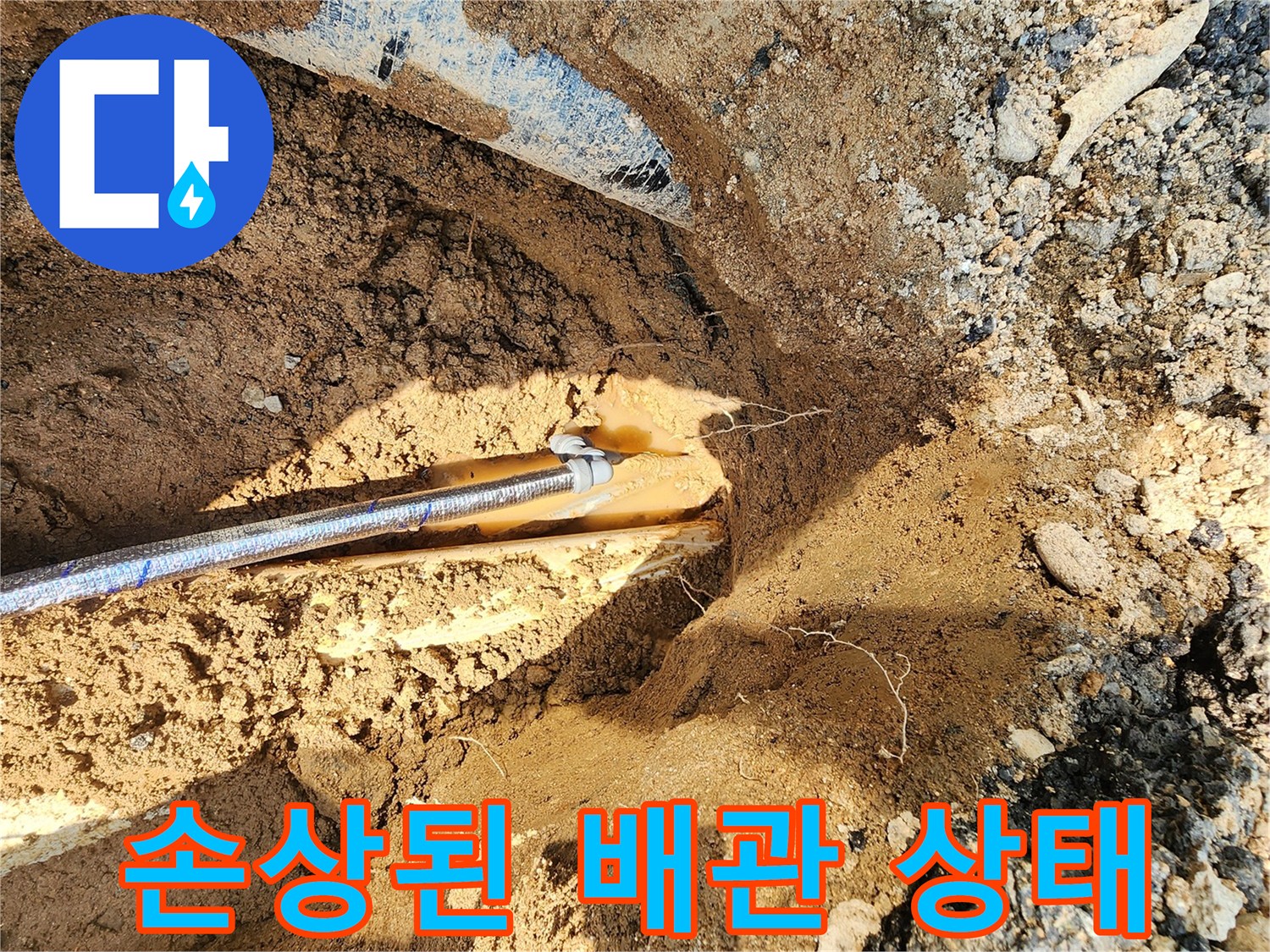 굴착 작업으로 인해 드러난 파손된 상수도 배관의 근접 사진입니다.