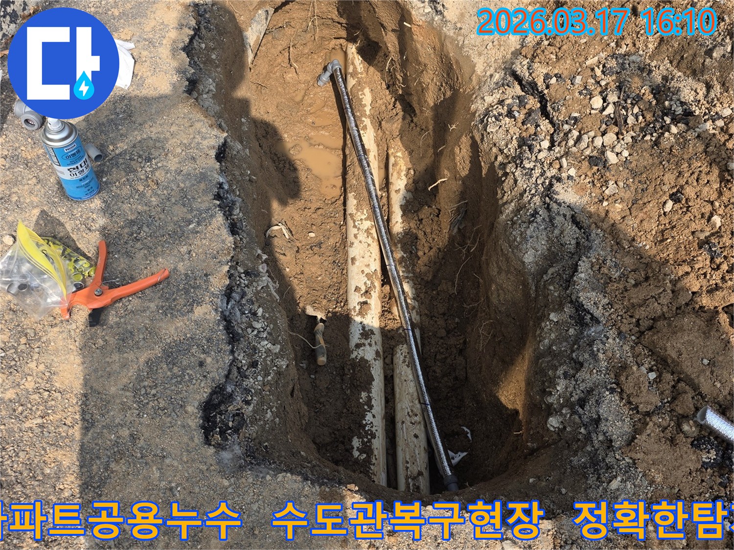 이 이미지는 양주-율정동 아파트 단지에서 발생한 공용 수도관 누수를-정확히 탐지하고-복구하기 위한 굴착 현장을 보여줍니다.