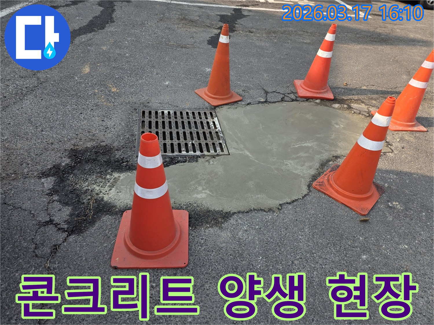 지하-배관-누수-보수-후-손상된-도로를-콘크리트로-복구하고-안전-콘을-설치한-현장-사진입니다.