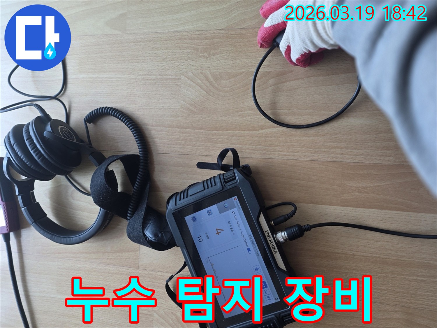 누수 탐지 장비와-헤드폰을 사용하여-바닥에서 발생하는-미세한 누수음을 포착하고-분석하는-전문가의 작업 모습입니다