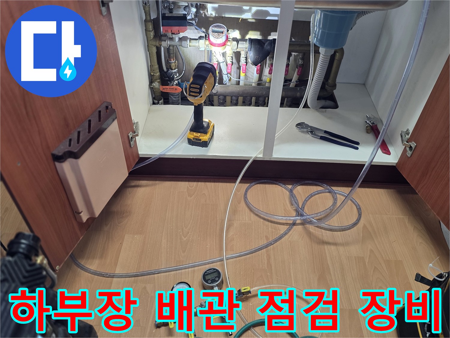 싱크대 아래 분배기와 연결된 공압 테스트용 게이지와 튜브