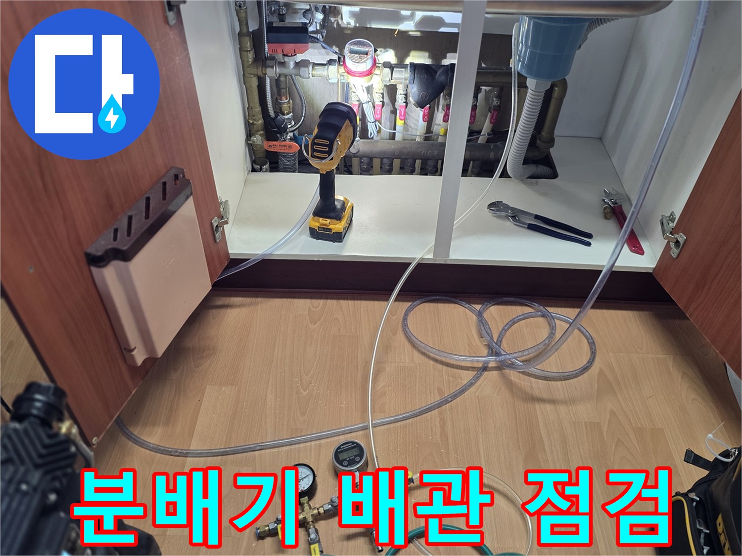 싱크대 하부 분배기에 연결된 공압 테스트용 매니폴드 게이지