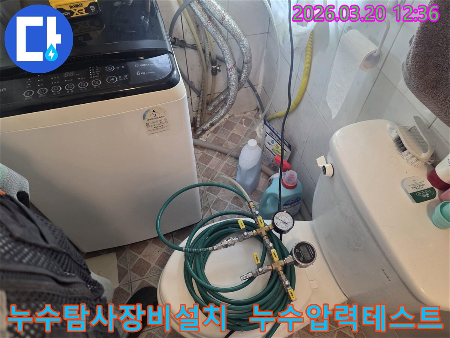누수 엔지니어가 화장실 변기 위에-누수 탐지용 압력 게이지와 호스를 설치하여-배관의 누수 여부를 정밀하게 검사하고 있습니다
