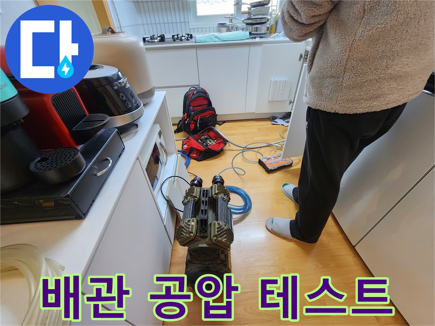 주방 싱크대 하부 바닥에 배치된 전문적인 누수 탐지 장비들