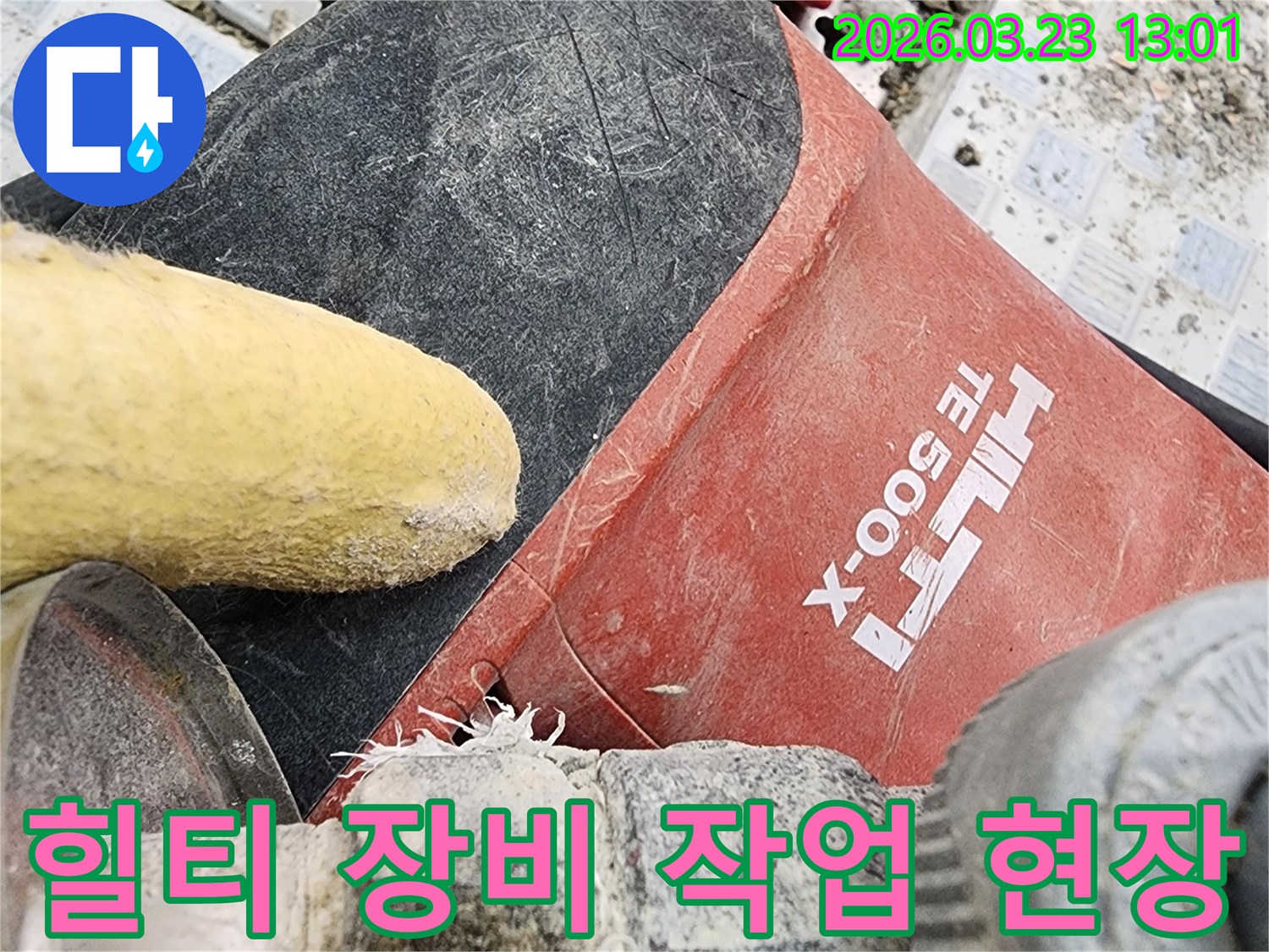 누수 공사 현장에서 바닥을 파쇄하는 힐티-TE-500-X 장비와 작업자의 안전 장갑이 클로즈업된 모습